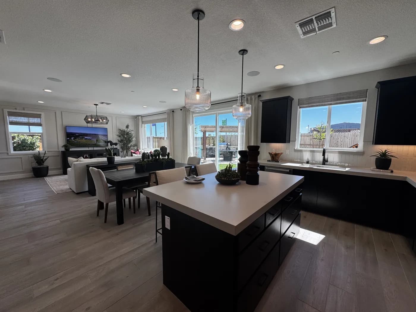 Amoruso Ranch kitchen with quartz waterfall island, dark cabinets, and pendant lighting