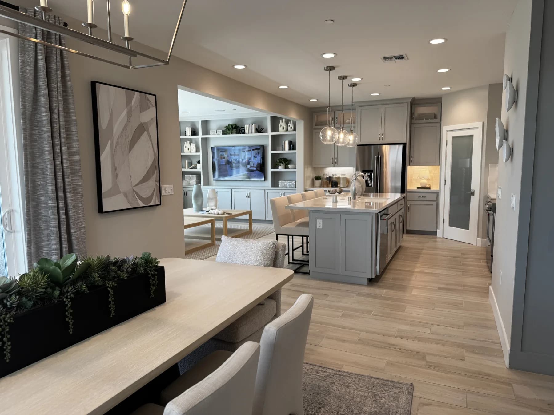 Open-concept great room at Amoruso Ranch with dining nook, kitchen island, and built-in entertainment center
