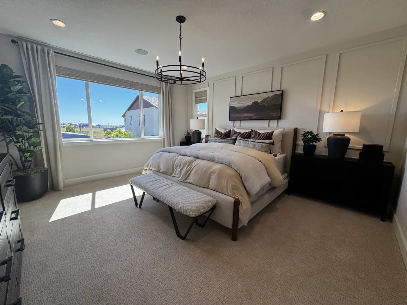 Primary bedroom at Amoruso Ranch with king bed, decorative panel wall, and oversized window