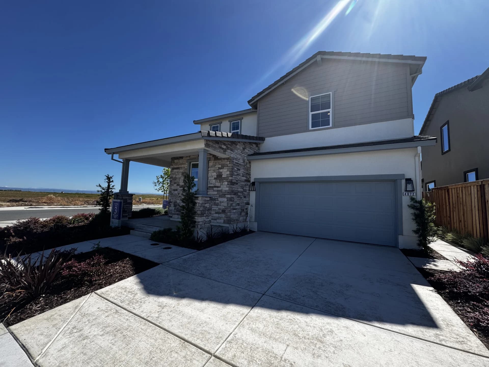 Front elevation of an Amoruso Ranch new construction home in Roseville, CA — two-story stucco with stone accent and covered porch